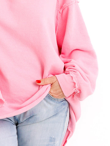 Detailaufnahme des rosafarbenen Oversize-Sweaters CARLY.S von Silberstern: Ärmel, Saum und sichtbare Nähte, kombiniert mit heller Jeans.