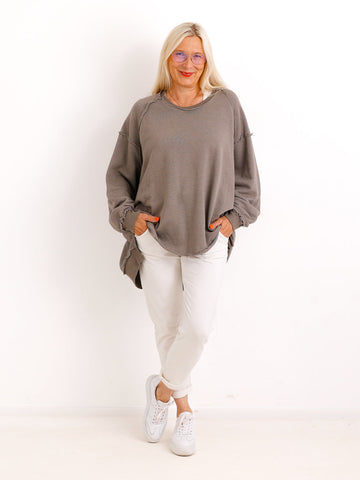 Silberstern Oversize-Sweater CARLY.S in Taupe mit Inside-Out-Nähten, getragen von einem Model mit heller Hose und Sneakern