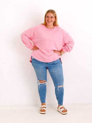 Silberstern Oversize-Sweater CARLY.S in Rosa aus Baumwolle mit Inside-Out-Nähten, getragen von einem lächelnden Model.